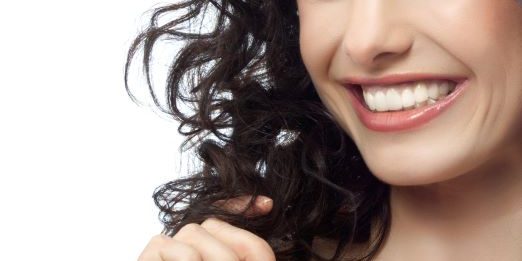 woman smiling with bright white, straight teeth after visiting cosmetic dentist