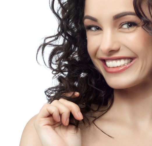woman smiling with bright white, straight teeth after visiting cosmetic dentist