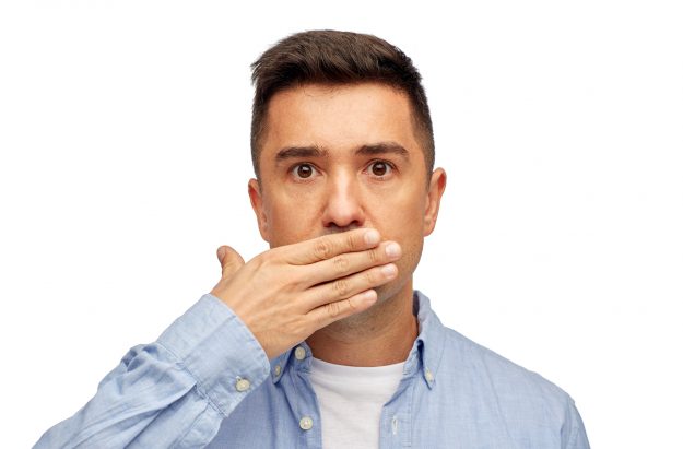 portrait of man covering mouth because of bad breath on white background portrait of man covering mouth because of bad breath on white background