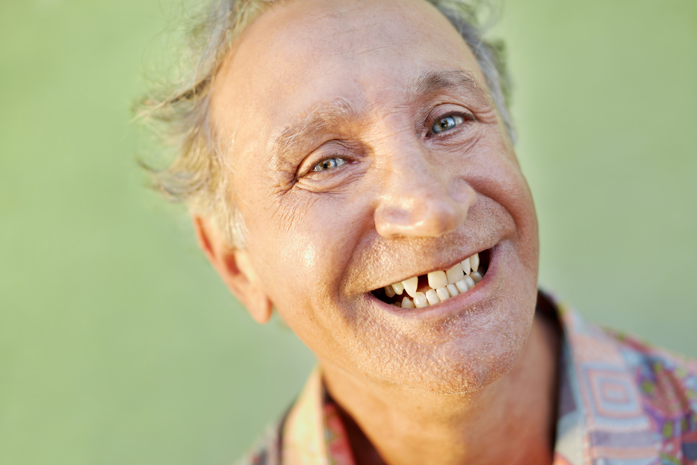 senior man smiling after tooth extraction