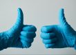 thumbs up in blue dental gloves