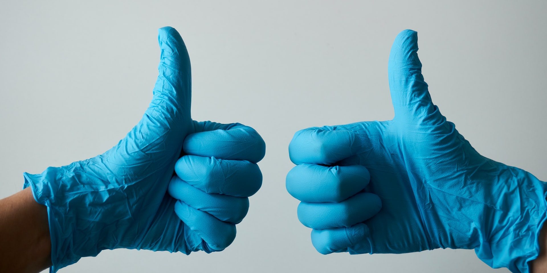 thumbs up in blue dental gloves