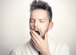 man holding jaw with mouth open-bruxism and tmj