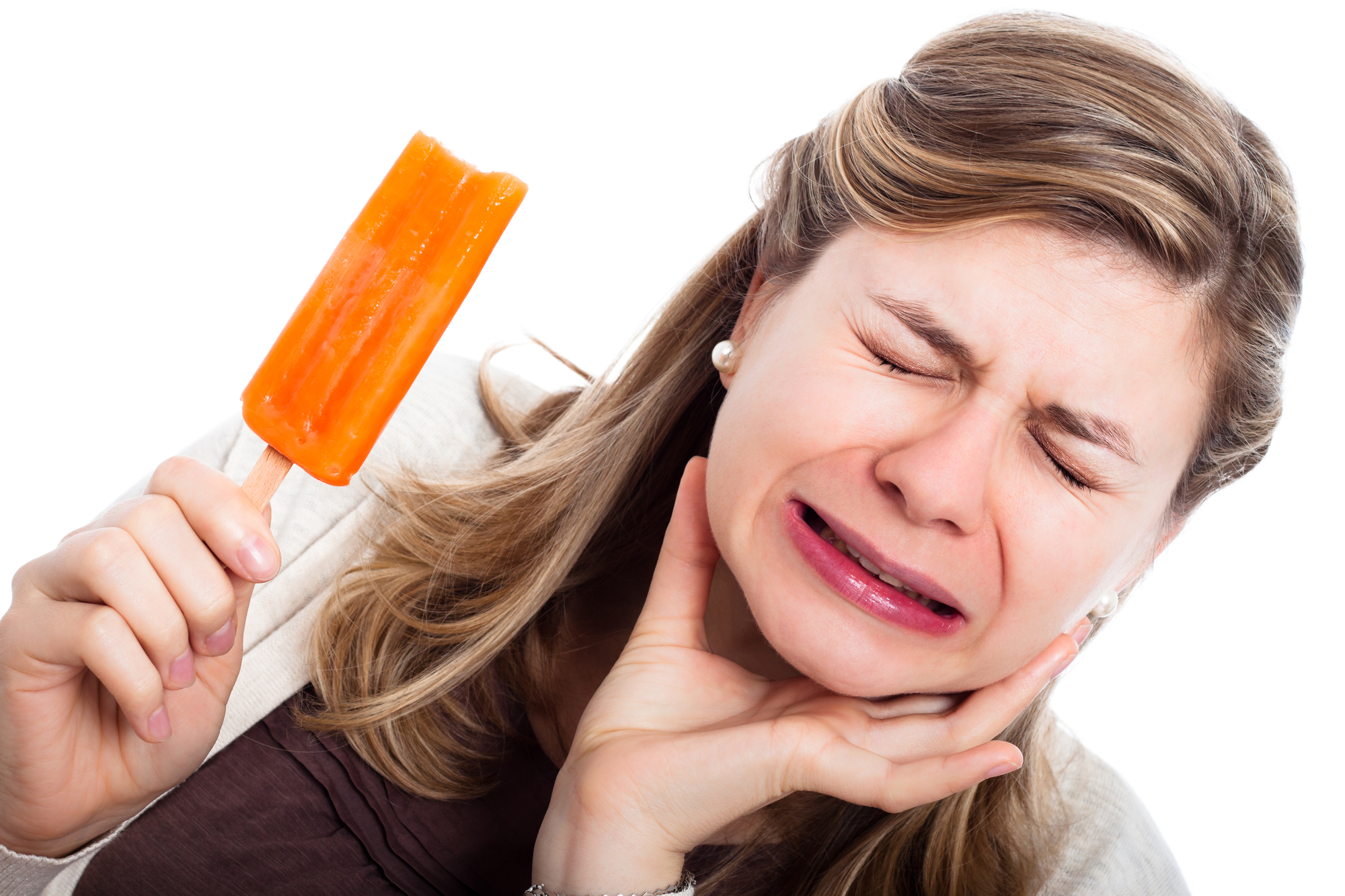 Woman eating ice cream experiences oral pain, indicating that she needs a dentist in lafayette, LA